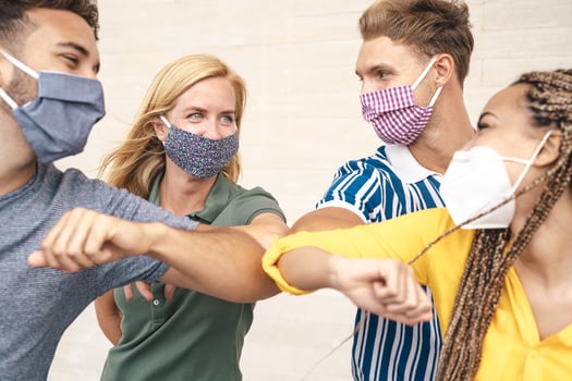 Young friends wearing face mask doing new social distancing greet with elbows bumps for preventing corona virus spread - Physical distance and friendship safety greetings concept photo