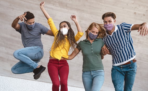 Young friends dancing together while wearing face mask outdoor - Happy people having fun in city after corona virus quarantine - Youth millennial generation friendship and health care concept photo