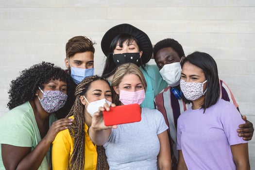 Group young people wearing face mask taking selfie with mobile smartphone outdoor - Millennial friends with different race and culture portrait - Multiracial and technology concept photo