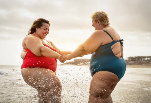 Happy plus size women having fun on the beach during summer vacation - Curvy confident people lifestyle concept photo