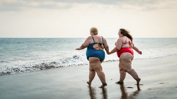 Happy plus size women having fun on the beach during summer vacation - Curvy confident people lifestyle concept photo