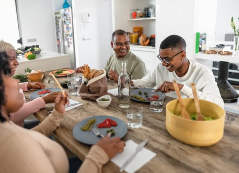 Happy black family enjoying while having healthy lunch together at home - Food and parents unity concept photo
