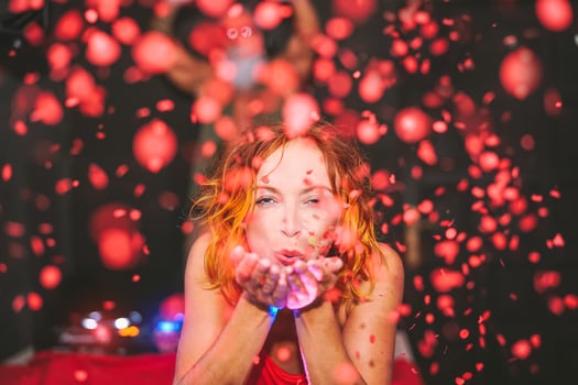 Happy woman throwing confetti in disco club - Young girl having fun moments celebrating in bar - People, nightlife, nightclub and youth holidays concept photo