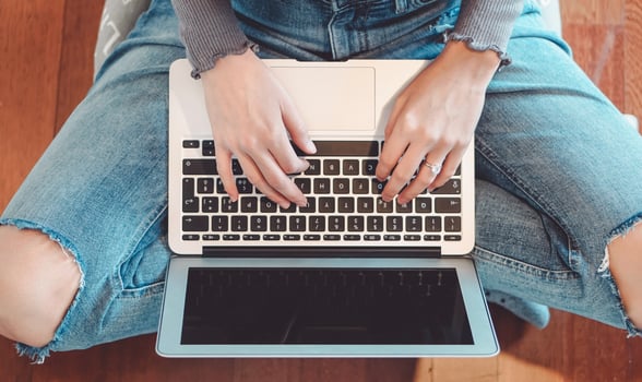 Young girl using laptop at home - Woman having fun with new technology computer while sitting on the floor - People, youth , tech and work concept photo
