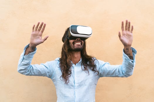 Happy man using virtual reality headset outdoor - Trendy guy having fun with innovated vr googles technology - Tech lifestyle entertainment and 3d game experience concept - Yellow background photo