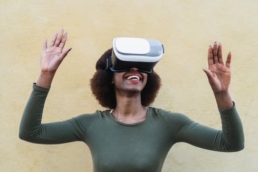 Afro woman using virtual reality glasses outdoor - Happy young girl having fun with innovated vr googles technology - Tech lifestyle entertainment and 3d game experience concept photo
