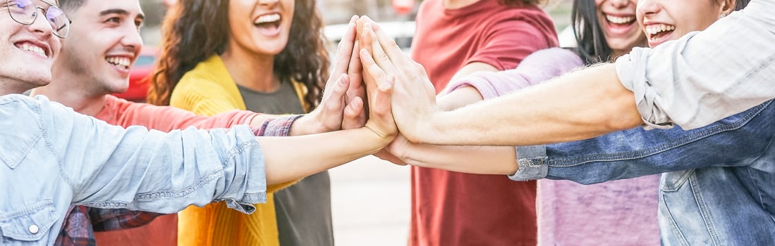 Group of diverse friends stacking hands outdoor - Happy young people having fun joining and celebrating together - Millennials, friendship, empowering, partnership and youth lifestyle concept photo