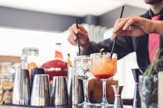 Barman preparing cocktails in entertainment bar - Bartender mixing drinks and serving clients in nightclub - People working and profession job lifestyle concept photo