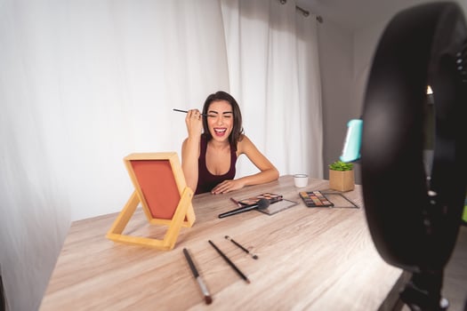 Young female vlogger doing makeup tutorial video for web channel at home - Happy influencer girl having fun filming with mobile smartphone - Social media and millennial generation lifestyle concept photo