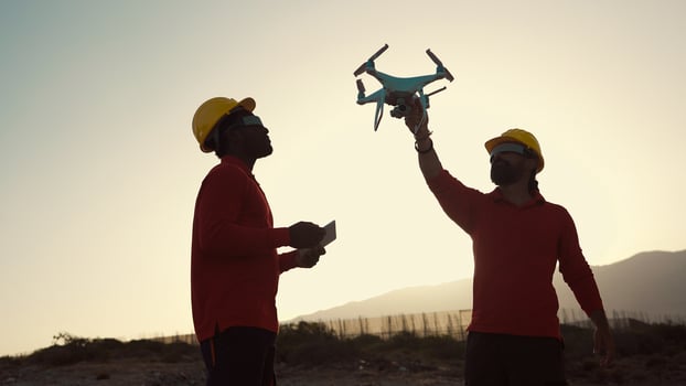Drone engineers working on construction site - Aerial engineering concept photo