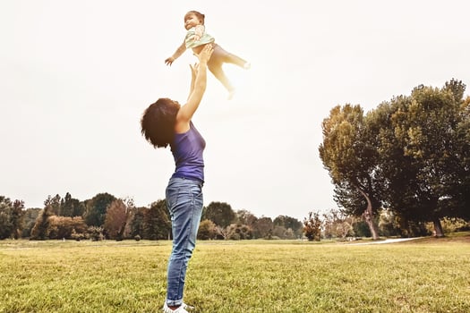 Happy family having fun in park outdoor - Mother and daughter enjoying good time playing together outside - Parents people and positive emotion concept photo
