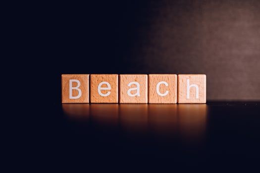 Wooden blocks form the text Beach against a black background. photo