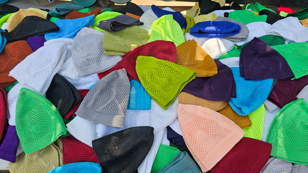 many different colored prayer hats or caps are piled up on top of each other photo