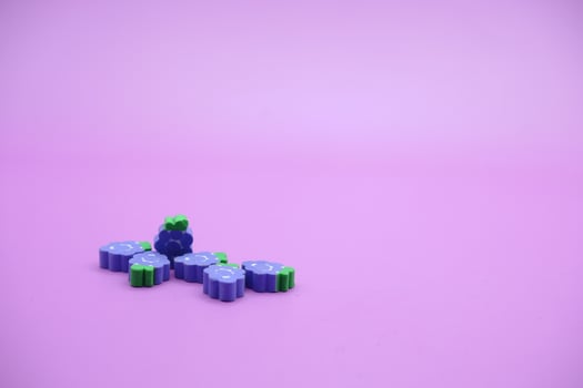 purple background with grape toys. Grape-shaped eraser isolated on purple background. photo
