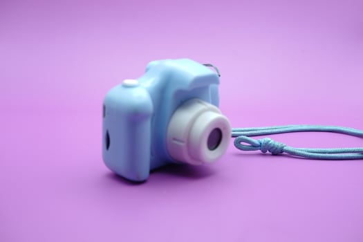 toy camera isolated on purple background. blue children's toy camera. photo