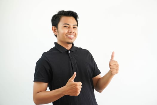 Happy or smiling young Asian man giving two thumbs up wearing black polo t shirt isolated on white background photo