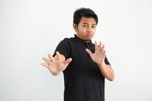 young asian man, being shocked due to an imminent danger wearing black polo t shirt isolated on white background photo