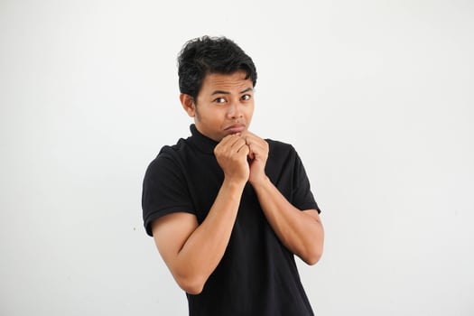 young asian man posing scared and afraid wearing black polo t shirt isolated on white background photo