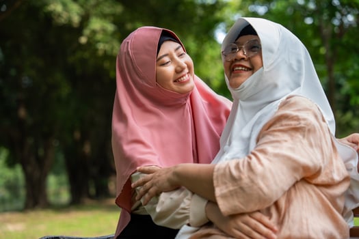 Muslim careful caregiver or nurse taking care of the patient in the hospital park. Happy Muslim mother in hijab hugging daughter. Concept of Savings and Senior Health Insurance, a Happy Family photo