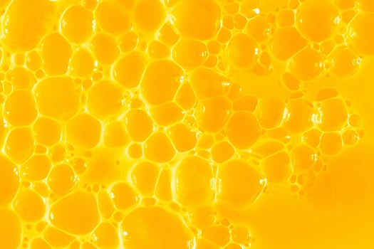 Orange juice. Bubble yellow texture background. Berry gel to cleanse the skin of the face and body. Spa treatments, skin care. Bath foam, detergent. Gold slime photo