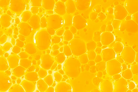 Orange juice. Bubble yellow texture background. Berry gel to cleanse the skin of the face and body. Spa treatments, skin care. Bath foam, detergent. Gold slime photo