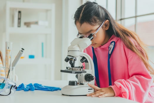 children using microscopes to study science at school photo