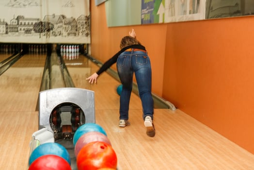 woman playing bowling, rear view photo