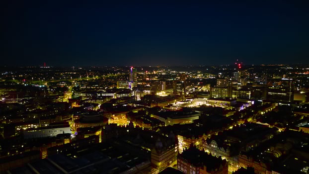 Aerial night view of a cityscape with illuminated buildings and streets, showcasing urban nightlife and architecture in Leeds. photo