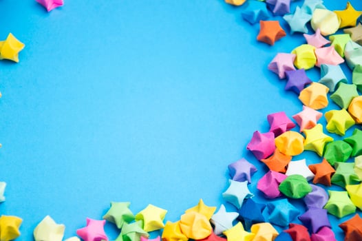 Paper folded into the shape of a multi-colored 5-pointed star, on a blue background. photo