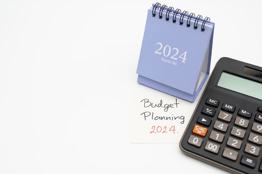 Budget Planning 2024 text message by hand writing on paper note, Calendar 2024 and Calculator. Budget planning concept. isolated on white background. photo