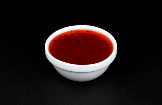 Cranberry sauce in bowl isolated on black background photo