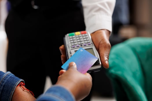 Cashless payments in hotels. Hospitality worker holding pos terminal accepting credit card payment from customer, close up of person making convenient and quick contactless transaction photo