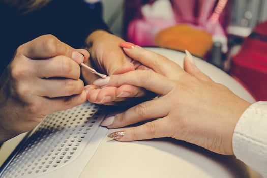 Girl paint nails in the salon of manicure, close-up photo
