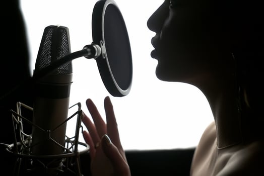 Girl singing to the microphone in a studio. Female vocal. Black and White. photo