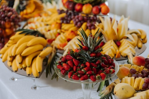 A banquet table full of fruits and berries, an assortment of sweets. Bananas, grapes, pineapples. Fruit compositions for the holiday. photo