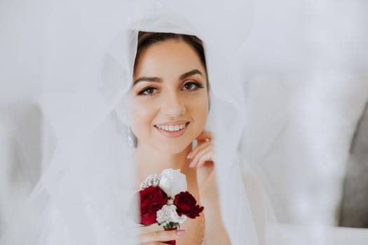 Wedding boutonniere of flowers in the hands of the bride. Wedding details. The first meeting of the bride and groom. The bride is waiting for the groom. Portrait of the bride. photo