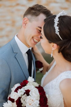 A young bride and groom tenderly embrace in the rays of the autumn sun. Tender and beautiful young girl bride. A man kisses his beloved. Against the background of a beautiful garden photo
