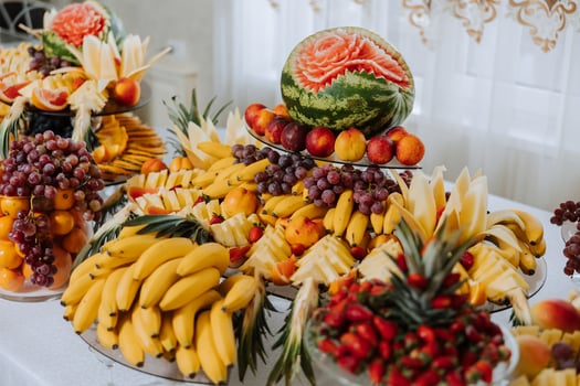 A banquet table full of fruits and berries, an assortment of sweets. Bananas, grapes, pineapples. Fruit compositions for the holiday. photo