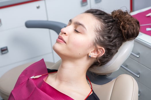 Dentist examining teeth of a young woman patient in a dental clinic. Dentistry concept. Dentist and patient in the dental office. photo
