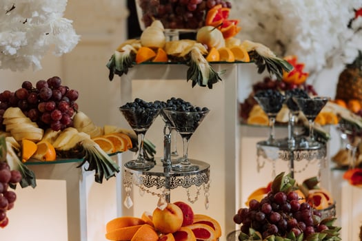 A banquet table full of fruits and berries, an assortment of sweets. Bananas, grapes, pineapples. Fruit compositions for the holiday. photo