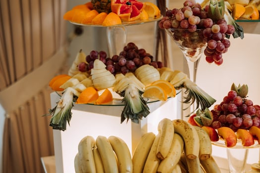 A banquet table full of fruits and berries, an assortment of sweets. Bananas, grapes, pineapples. Fruit compositions for the holiday. photo