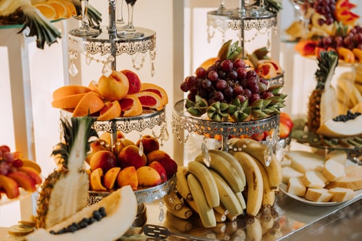 A banquet table full of fruits and berries, an assortment of sweets. Bananas, grapes, pineapples. Fruit compositions for the holiday. photo