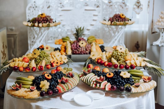 A banquet table full of fruits and berries, an assortment of sweets. Bananas, grapes, pineapples. Fruit compositions for the holiday. photo