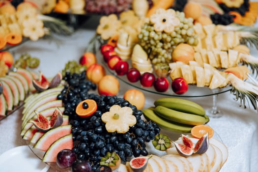 A banquet table full of fruits and berries, an assortment of sweets. Bananas, grapes, pineapples. Fruit compositions for the holiday. photo