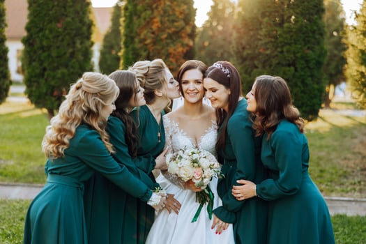 Wedding photography. A brunette bride in a wedding dress and her friends in emerald dresses photo