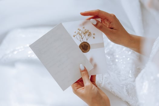 The bride in her hands holds a white envelope, an invitation, a gift sheet of paper. Close-up wedding photography, copy space, portrait. photo