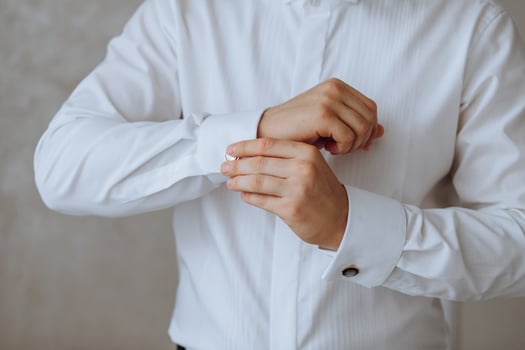 The man put on his shirt and straightens cufflinks. The groom fasten cufflinks on the cuffs of the shirt. The businessman fasten cufflinks on the cuffs of the shirt. Concept successful businessman. photo