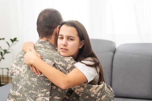 pretty little girl hugging her military father photo