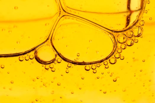 Golden yellow abstract oil bubbles or face serum background. Oil and water bubbles macro photography. photo