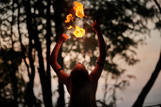 Girl fire dancing performance at outdoor art festival, smooth movements of female artist photo